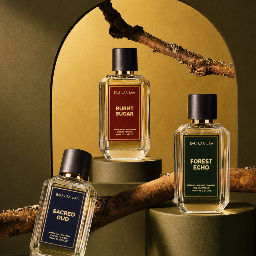 Three perfume bottles labeled 'Burnt Sugar', 'Forest Echo', and 'Sacred Oud' on a decorative background.